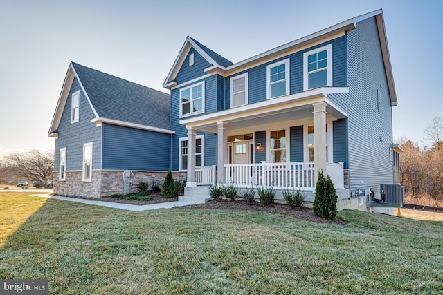 view of front facade with central AC unit, covered porch, and a front lawn