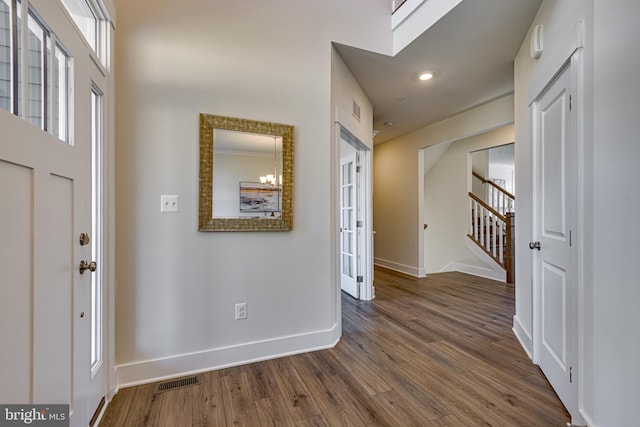 foyer entrance with a chandelier and dark hardwood / wood-style flooring