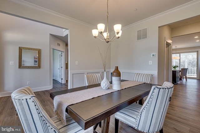 dining room featuring dark hardwood / wood-style flooring, a notable chandelier, and ornamental molding