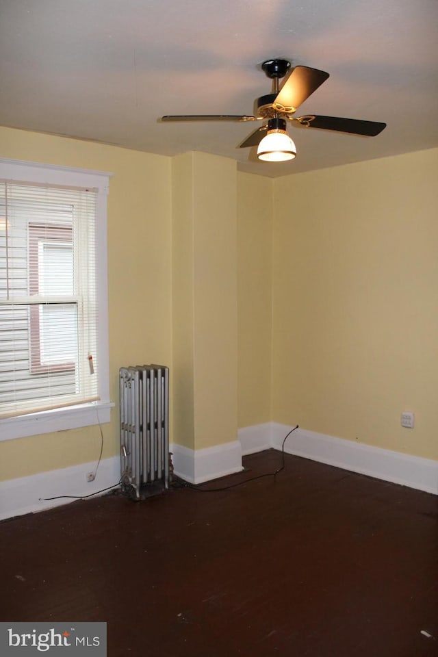 empty room featuring ceiling fan and radiator heating unit