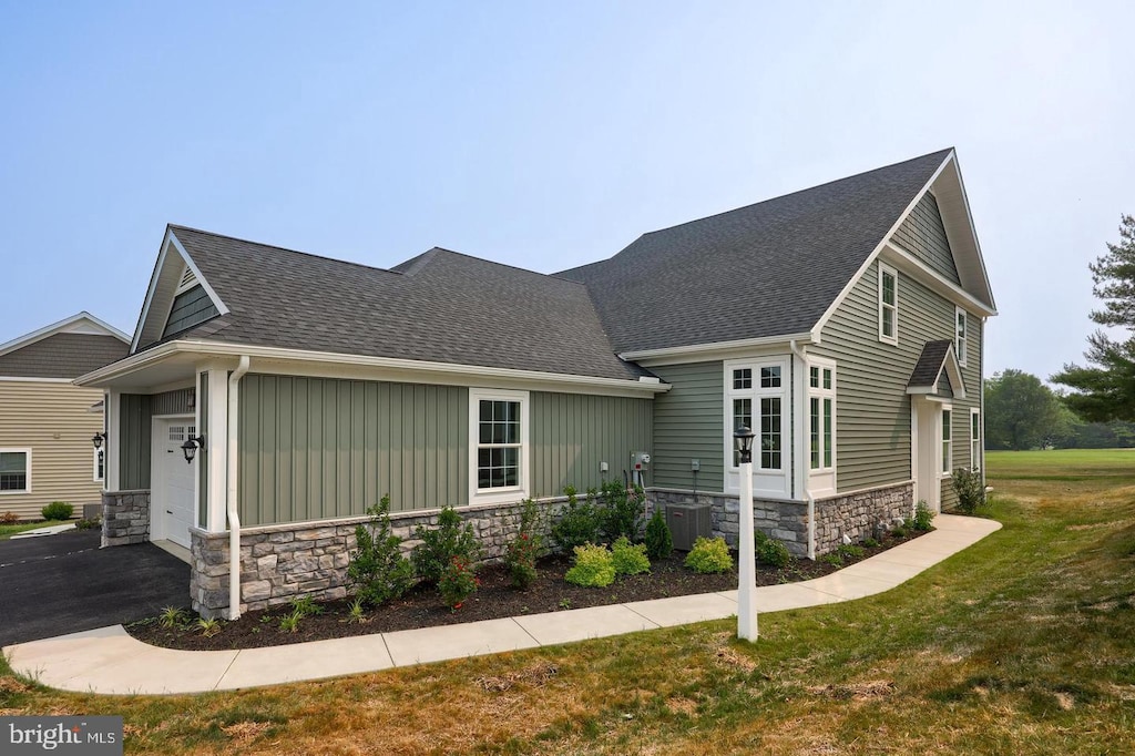 view of side of home with a lawn and a garage