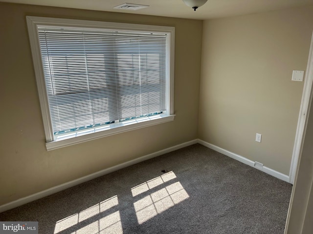 spare room featuring dark carpet