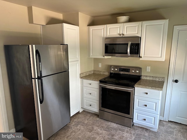 kitchen featuring light stone counters, dark colored carpet, appliances with stainless steel finishes, and white cabinetry