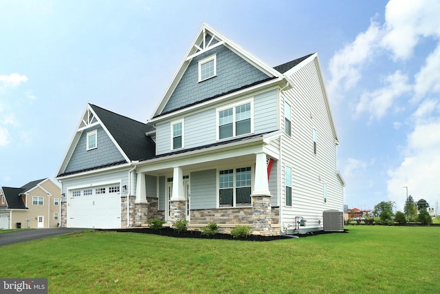 view of front of house featuring a front lawn, central air condition unit, and covered porch