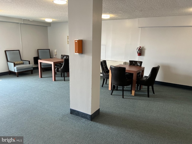 dining space featuring a textured ceiling and dark colored carpet