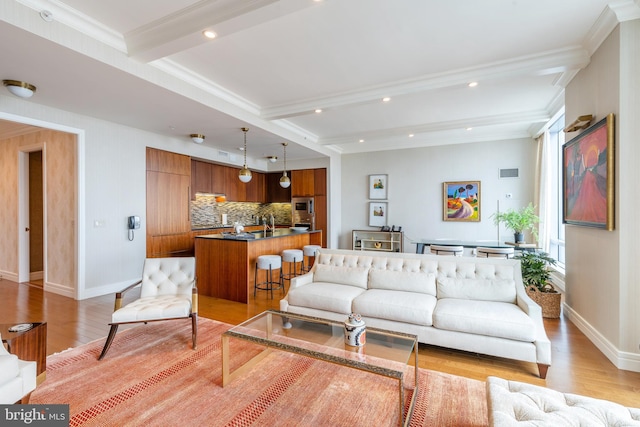 living room featuring crown molding, light hardwood / wood-style flooring, and beamed ceiling