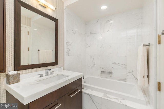 bathroom featuring tiled shower / bath and vanity