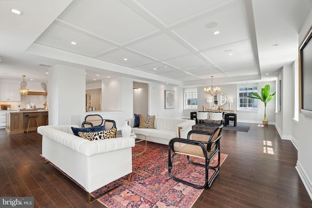 living room with an inviting chandelier, coffered ceiling, and dark hardwood / wood-style floors