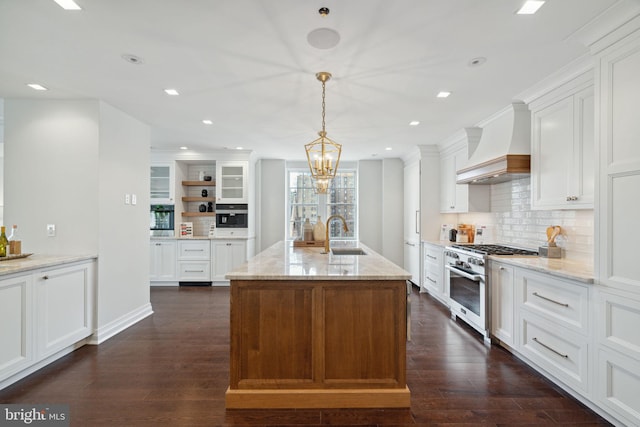 kitchen with dark wood-type flooring, white cabinetry, custom exhaust hood, high end range, and light stone countertops