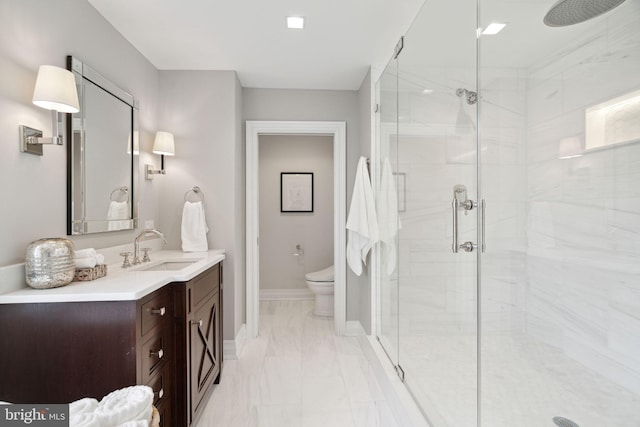 bathroom with tile flooring, toilet, oversized vanity, and a shower with shower door