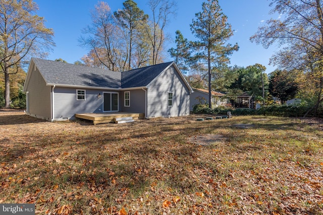 back of house featuring a wooden deck and a yard