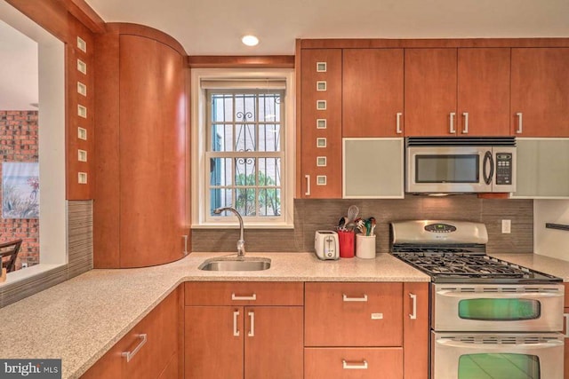 kitchen with appliances with stainless steel finishes, tasteful backsplash, and sink