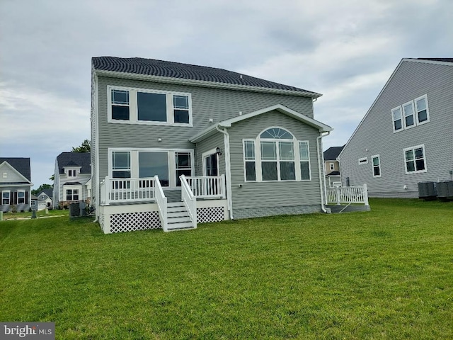 back of house with central AC and a yard