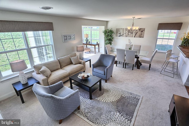 carpeted living room with an inviting chandelier and a wealth of natural light