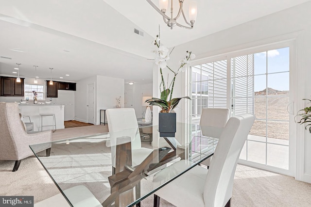 dining area featuring an inviting chandelier and light carpet