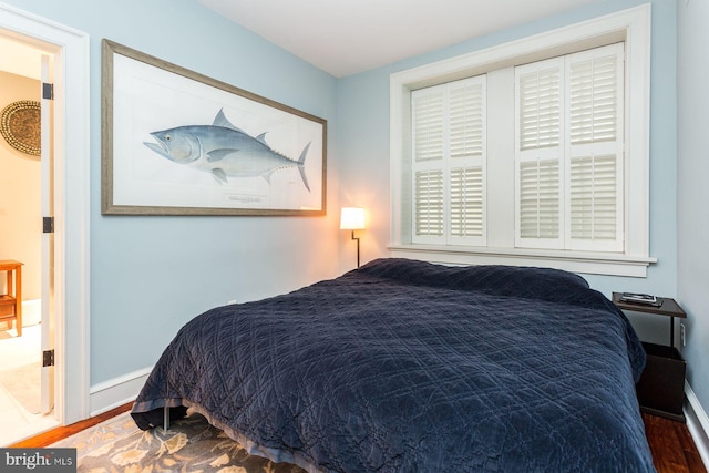 bedroom with dark hardwood / wood-style flooring