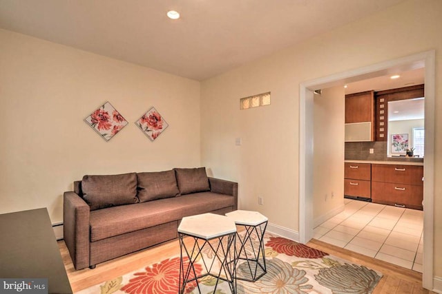 tiled living room with a baseboard heating unit