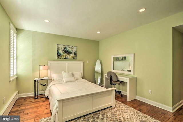 bedroom with a baseboard radiator and dark hardwood / wood-style floors