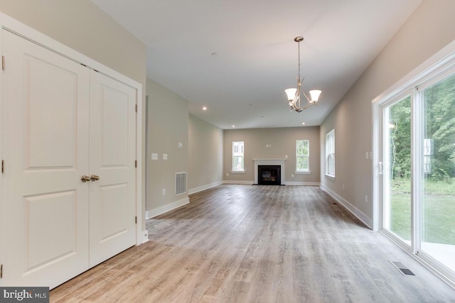 unfurnished living room featuring light hardwood / wood-style floors and a notable chandelier