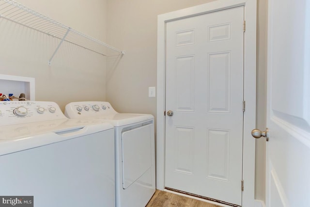 laundry room featuring hookup for a washing machine, washer and dryer, and light hardwood / wood-style flooring