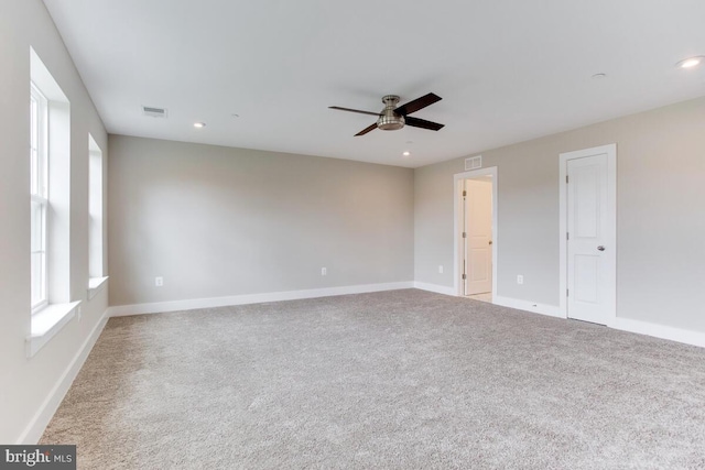 spare room with ceiling fan and light carpet