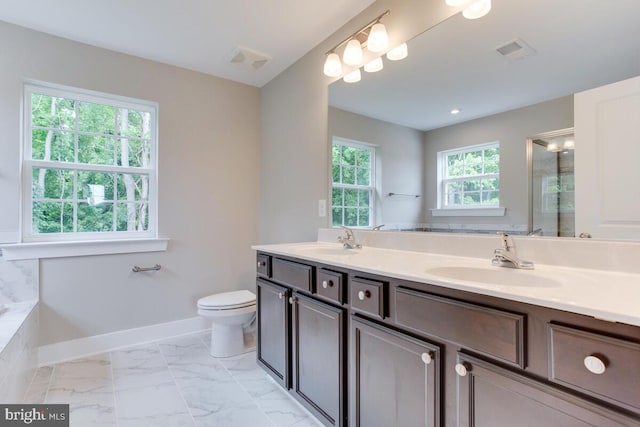 bathroom featuring double sink, a healthy amount of sunlight, oversized vanity, and toilet