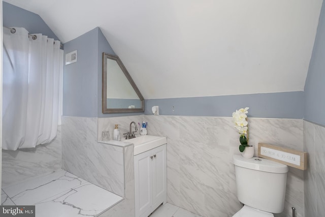 bathroom featuring vanity, tile walls, tile flooring, toilet, and vaulted ceiling