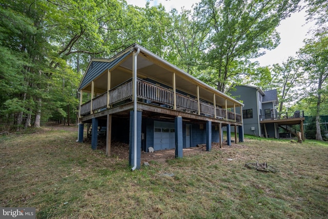 rear view of property featuring a wooden deck and a lawn