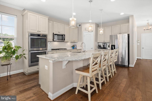 kitchen featuring hanging light fixtures, appliances with stainless steel finishes, a chandelier, tasteful backsplash, and dark hardwood / wood-style flooring