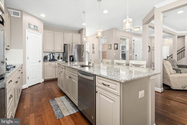 kitchen with backsplash, decorative light fixtures, a kitchen island with sink, and dark hardwood / wood-style flooring