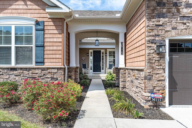 doorway to property with a porch and a garage