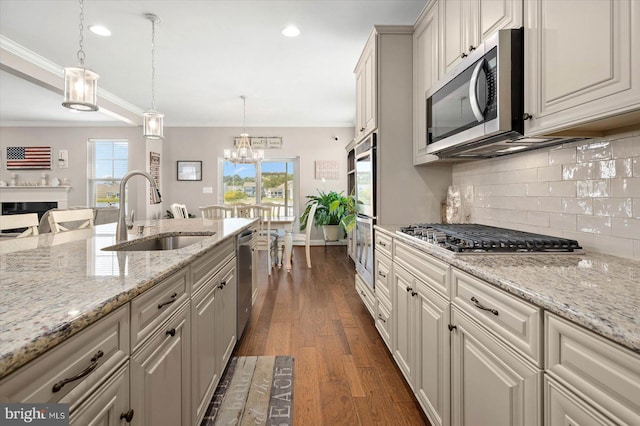 kitchen featuring stainless steel appliances, decorative light fixtures, crown molding, dark hardwood / wood-style floors, and sink