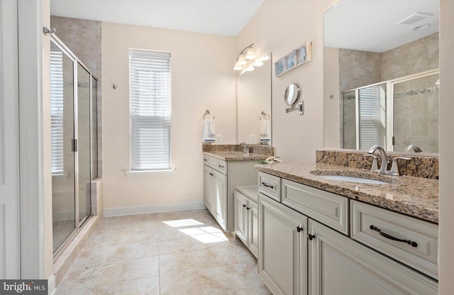 bathroom featuring tile flooring, double sink, oversized vanity, and a shower with shower door