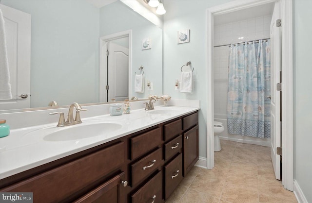 bathroom with tile flooring, toilet, and double vanity