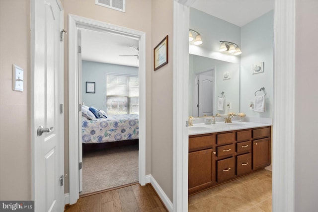 bathroom with ceiling fan, dual vanity, and tile floors