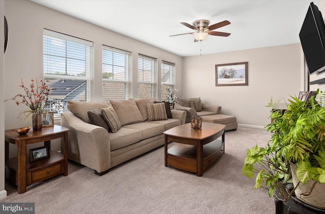 carpeted living room with ceiling fan