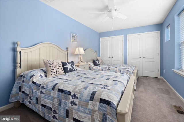 carpeted bedroom with multiple closets and ceiling fan