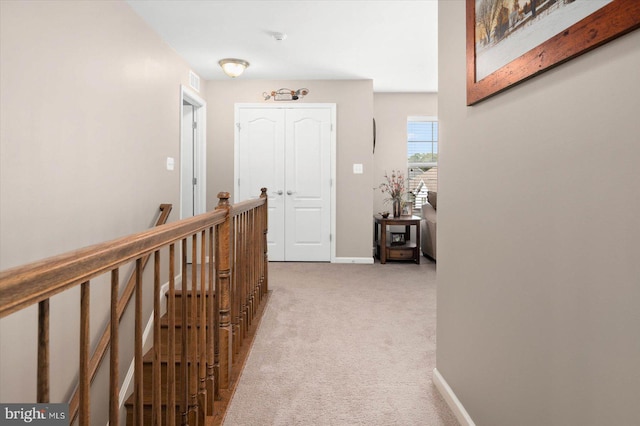 hallway featuring light colored carpet