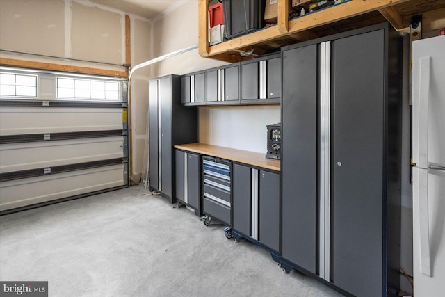 garage with stainless steel refrigerator and white fridge