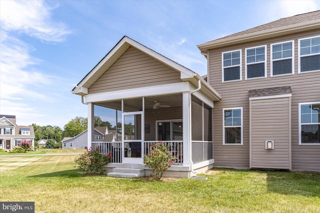 back of house with ceiling fan and a yard