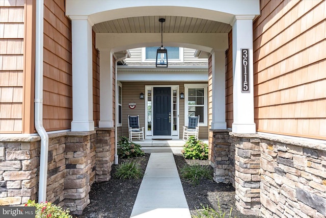 view of exterior entry featuring covered porch