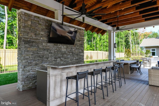 wooden terrace with ceiling fan and an outdoor bar