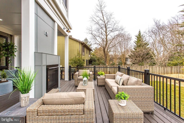 wooden terrace with an outdoor living space