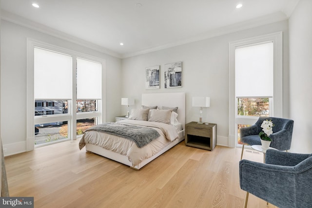 bedroom with light hardwood / wood-style floors and crown molding