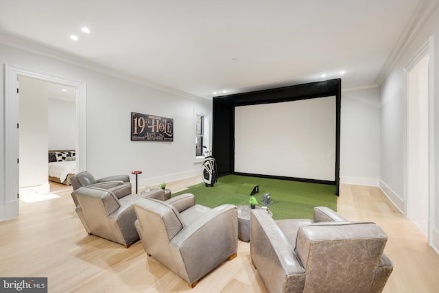 cinema room with crown molding, golf simulator, and light hardwood / wood-style floors