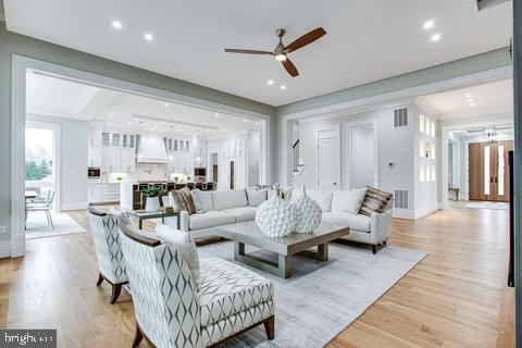 living room with ceiling fan and light wood-type flooring