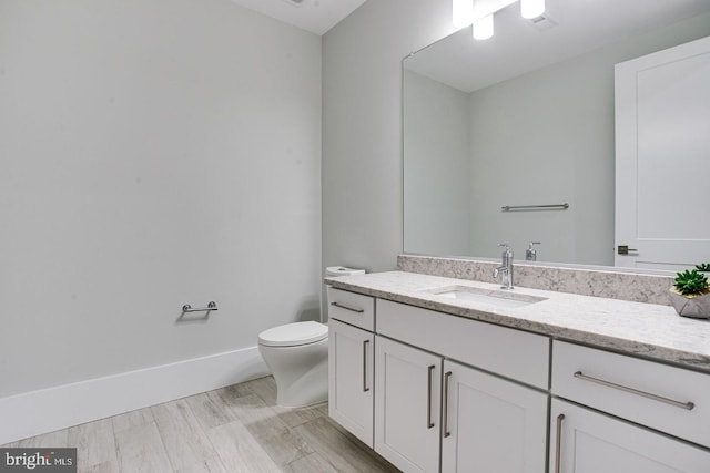 bathroom featuring vanity, toilet, and wood-type flooring