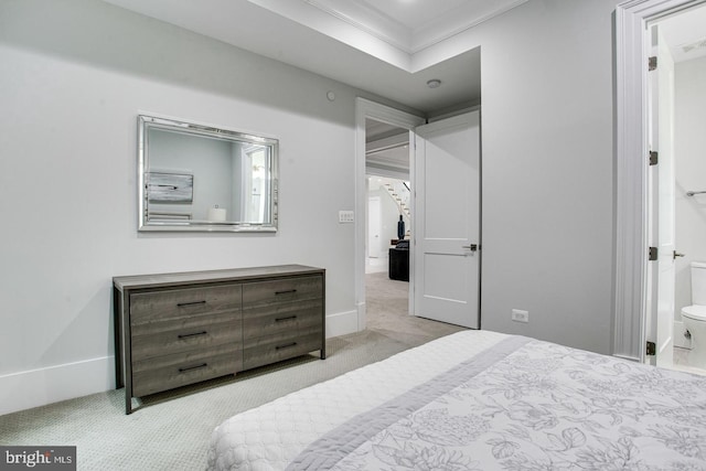 carpeted bedroom with connected bathroom and ornamental molding