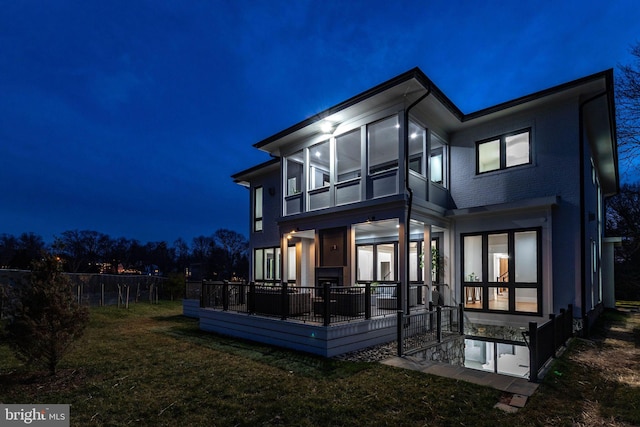 back house at twilight featuring a yard