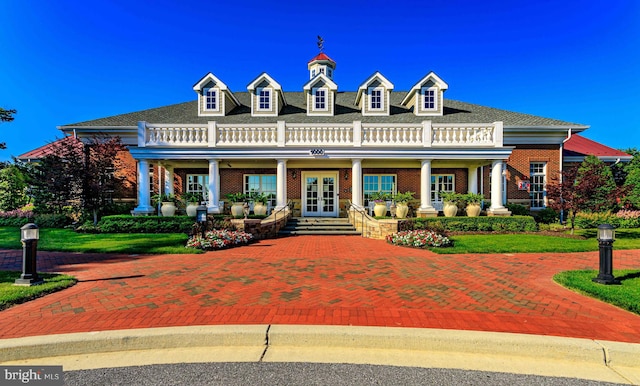 view of front of home featuring covered porch and french doors